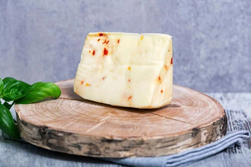 Pecorino Primosale z dodatkiem papryki peperoncino – włoski ser owczy na desce z dodatkami